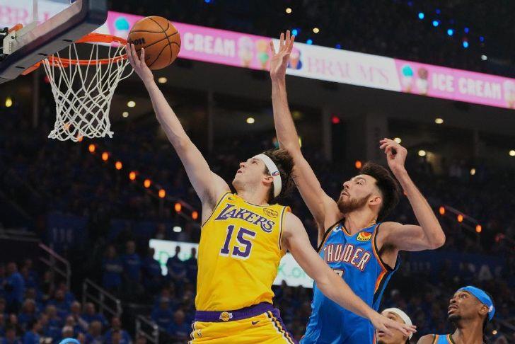 Los Angeles guard Austin Reaves (15) shoots after getting past Oklahoma City Thunder center Chet Holmgren, center, and Shai Gilgeous-Alexander, right, in the first half of Game 1 in a second-round playoff series game on May 5 in Oklahoma City.