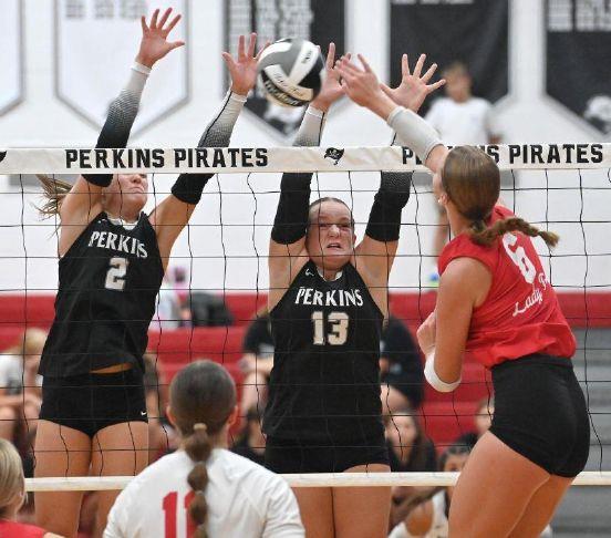 Perkins\' Brooklyn Cassidy (2) and Addi Mason (13) block as Bellevue\'s Finley LaPata (6) hits during a match at Perkins High School on Monday, Aug. 31, 2026.